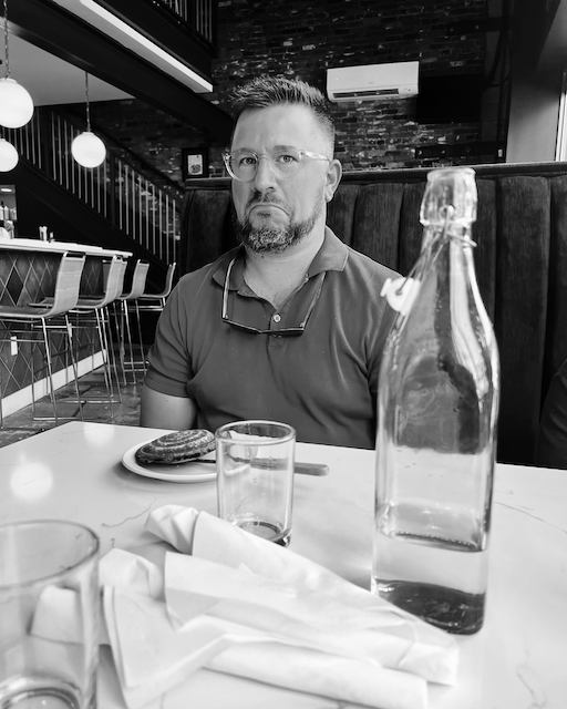 Jered, looking sad at the size of the sandwich on the plate in front of him.